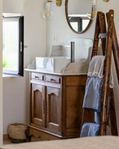 une salle de bain avec un lavabo et un miroir dans l'établissement Le Mas des Poules chambres d'hôtes de charme, à Saint-Roman-de-Malegarde