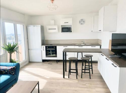 une cuisine avec une table et des tabourets dans une pièce dans l'établissement Chambre PRIVÉE dans Appartement PARTAGÉ - Résidence Palmer - Balcon - Tram A - REF P8, à Cenon