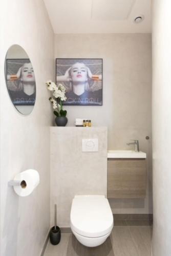 une salle de bain avec toilettes, lavabo et miroir dans l'établissement Lecerf Croisette, à Cannes