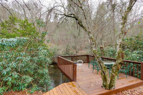 a wooden deck with a tree and chairs on it at Creek Bend Escape with Hot Tub and River Views! in McCaysville