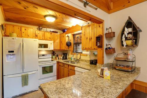 a kitchen with wooden cabinets and a white refrigerator at Creek Bend Escape with Hot Tub and River Views! in McCaysville
