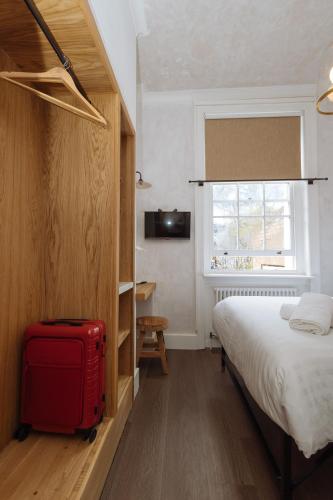 a bedroom with a bed and a red suitcase at Central Hotel in London