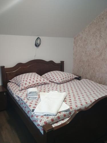a bed with a quilt with towels on it at NICO-ȘTEF in Vatra Dornei