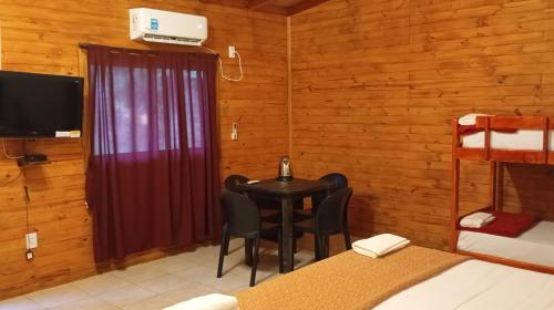 una habitación con mesa y sillas en una cabaña en Quinta Don Adolfo, en Puerto Iguazú