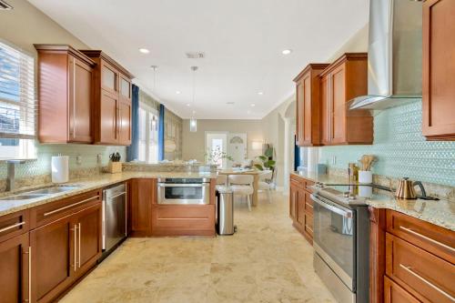 a large kitchen with wooden cabinets and a dining room at 5BR Villa with Heated Pool & BBQ - SoHo, Downtown Tampa and Airport in Tampa