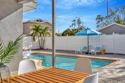 a house with a swimming pool and a table and chairs at 5BR Villa with Heated Pool & BBQ - SoHo, Downtown Tampa and Airport in Tampa