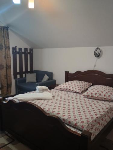 a bedroom with a bed and a blue couch at NICO-ȘTEF in Vatra Dornei