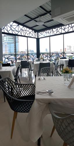 a dining room with white tables and chairs at Buendía Hotel in Barrancabermeja