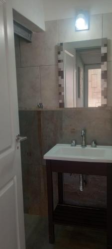 a bathroom with a sink and a mirror at Hostel El Chinchero in Merlo