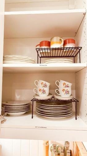 a closet filled with plates and cups and dishes at KingstonStays Historic Downtown Hideaway in Kingston