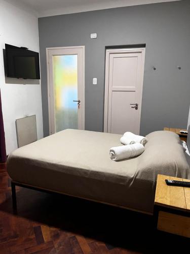 a bedroom with a bed with two towels on it at Sin Fin Hostel in Mendoza