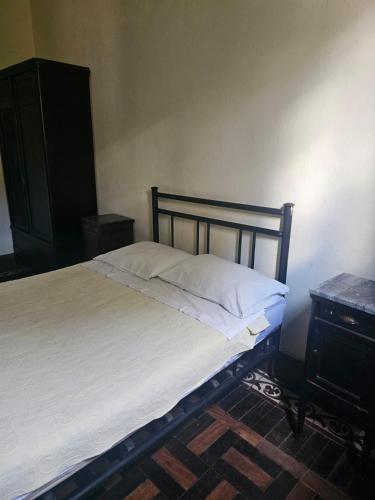 a bed in a bedroom with a wooden headboard and a table at Varzea Palace Hotel in Teresópolis