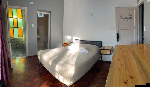 a bedroom with a large bed and a wooden floor at Sin Fin Hostel in Mendoza