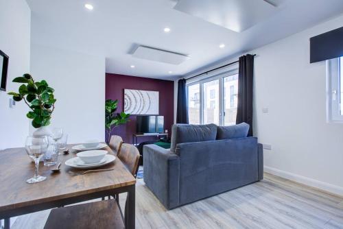 a living room with a blue couch and a table at 2bed 2bath In - Next To Station For 6 Free Parking in Ashford