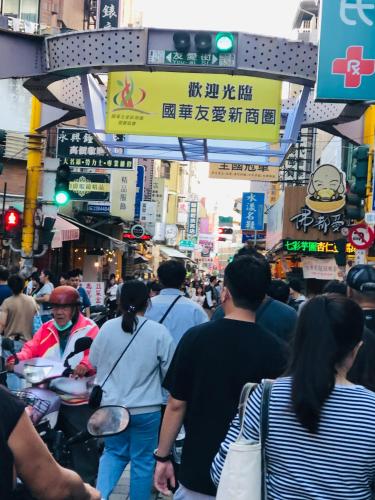 a crowd of people walking down a busy city street at Good Ground Hotel Tainan in Tainan