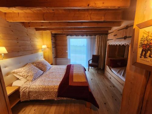 une chambre avec un lit dans une cabane en bois dans l'établissement Chalet le Clos de l'Orme, à Saint-Lattier
