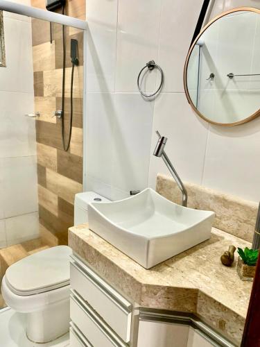 a bathroom with a sink and a toilet at Aconchegante casa em Marataizes in Marataizes