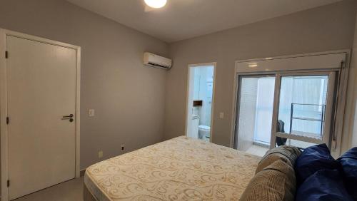 1 dormitorio con 1 cama y puerta al baño en Lazer completo no melhor do Gonzaga, cozinha top, Garagem, en Santos