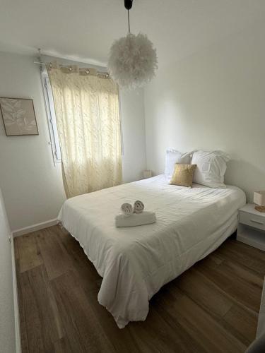 une chambre avec un grand lit avec deux serviettes dessus dans l'établissement Le cosy Parking gratuit piscine terrain de tennis, à Castelginest