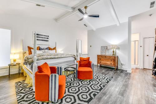 a bedroom with a bed and two orange chairs at Woodsy Concord Retreat about 11 Mi to Nascar! in Concord