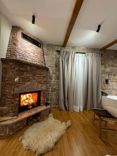a living room with a brick wall and a fireplace at Hotel Ambassador Voskopojë in Voskopojë