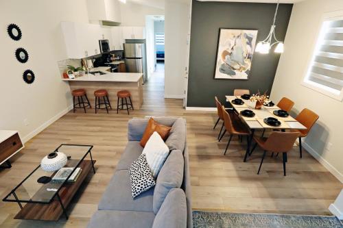 a living room with a couch and a table and a kitchen at Downtown 5 Bedroom, AC, Rogers, Commonwealth, EXPO in Edmonton