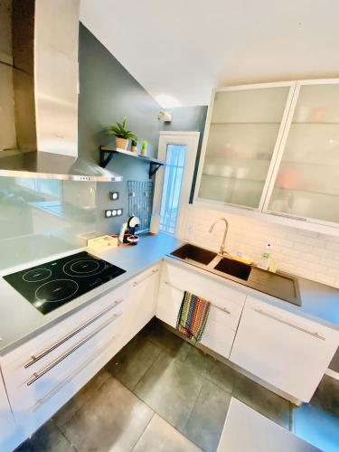 une cuisine avec des armoires blanches et un évier dans l'établissement Comfort & WiFi - Talence - 4 pers - tram B, à Talence