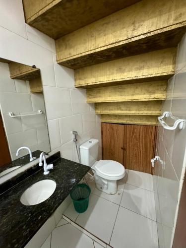 a bathroom with a white toilet and a sink at Casa Boa Vida GuestHouse in Itacaré