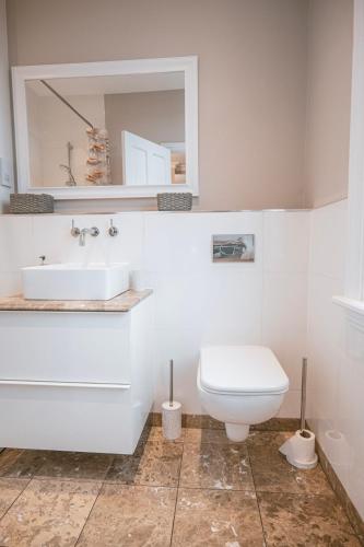 a white bathroom with a sink and a toilet at St Michaels Town House - Elegant and Large Holiday Home in the Heart of Gloucester in Gloucester