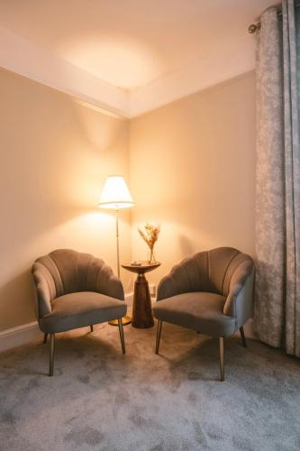 two chairs in a room with a lamp and a table at St Michaels Town House - Elegant and Large Holiday Home in the Heart of Gloucester in Gloucester