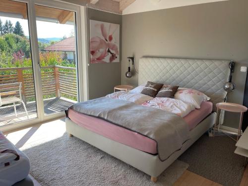 a bedroom with a bed and a balcony at Architekten-Villa, moderne 220qm, 4 Schlafzimmer, Garten in Irschenberg