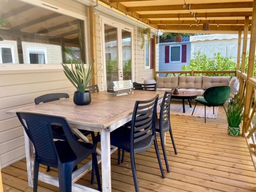 une terrasse avec une table et des chaises en bois. dans l'établissement Un toit sur le bassin les viviers, à Lège-Cap-Ferret