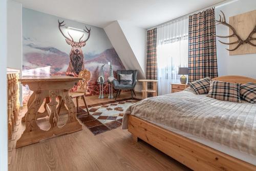 ビャウィ・ドゥナイェツにあるApartamenty TRZY IZBYのベッドルーム1室(壁に鹿が1匹いるベッド1台付)