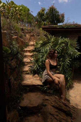 a woman sitting on a stone step next to a path at REFUGIO LA ROCA in Los Santos