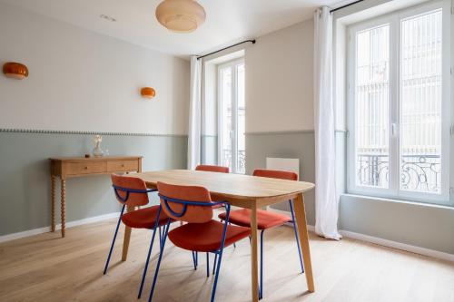 une salle à manger avec une table en bois et quatre chaises dans l'établissement Bubble House-Paris15-Mobility lease, à Paris