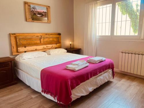 a bedroom with a bed with a red blanket on it at Lechuza del Campanario in San Antonio de Areco