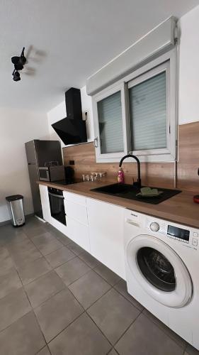 une cuisine avec une machine à laver dans une cuisine dans l'établissement Residence Villa rose T3 parking privé, à Toulouse