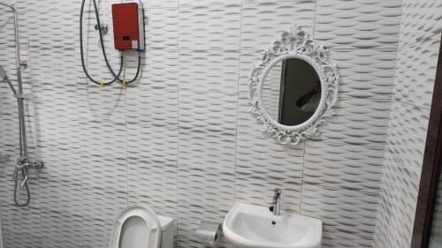 a bathroom with a sink and a mirror and a toilet at Jakara Avenue Hotel- Tamale in Kyanshiogo
