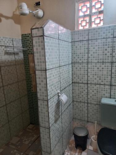 a bathroom with a toilet and a glass shower stall at Hostel X DE CARAIVA in Caraíva