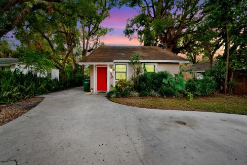 a house with a red door and a driveway at Zen Jungle House by Busch Gardens Sleeps 12 with Outdoor Games & Detached Play Space! in Tampa