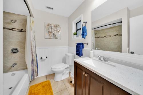 a bathroom with a sink and a toilet and a shower at Zen Jungle House by Busch Gardens Sleeps 12 with Outdoor Games & Detached Play Space! in Tampa