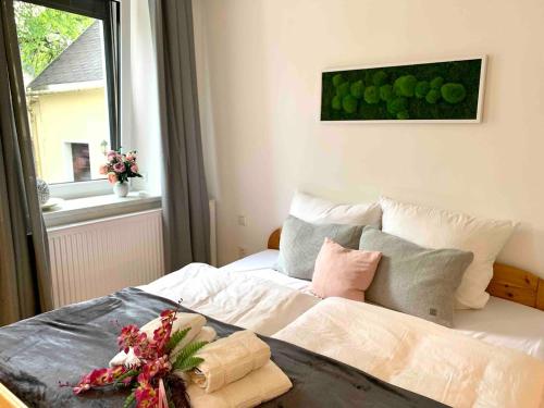 a bedroom with a bed with white sheets and a window at FeWo im Chalet Style mit Kamin und Wärmekabine in Geyer