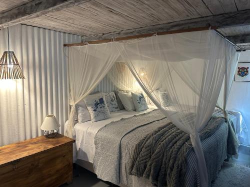 a bedroom with a canopy bed and a wooden table at VILA TRANCOSEAR in Trancoso