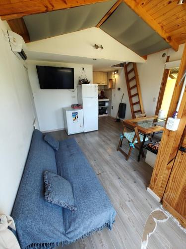 a room with a bed and a kitchen and a table at Cabaña Jardín del Río in Junín de los Andes