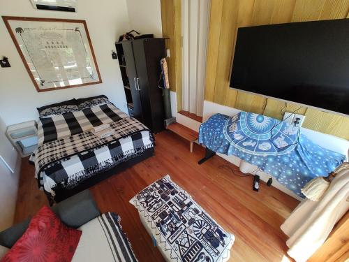a room with two beds and a flat screen tv at Cabaña Jardín del Río in Junín de los Andes