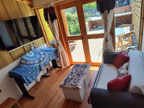 a living room with a couch and a table at Cabaña Jardín del Río in Junín de los Andes