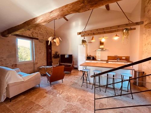a living room with a kitchen and a table at Le Moulin de Toquedonnes Gîte insolite in Saint-Michel