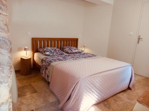 a bedroom with a bed with a wooden headboard at Le Moulin de Toquedonnes Gîte insolite in Saint-Michel