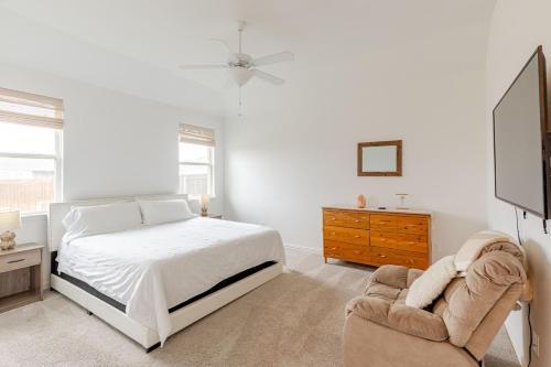a white bedroom with a bed and a chair at Southern Luxery Private Yard Tesla Plug BBQ Grill in Haslet