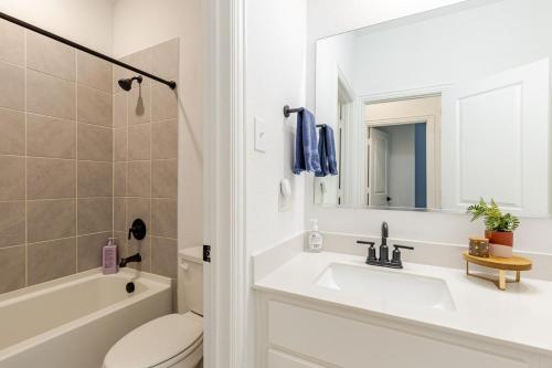 a bathroom with a sink and a toilet and a mirror at Southern Luxery Private Yard Tesla Plug BBQ Grill in Haslet